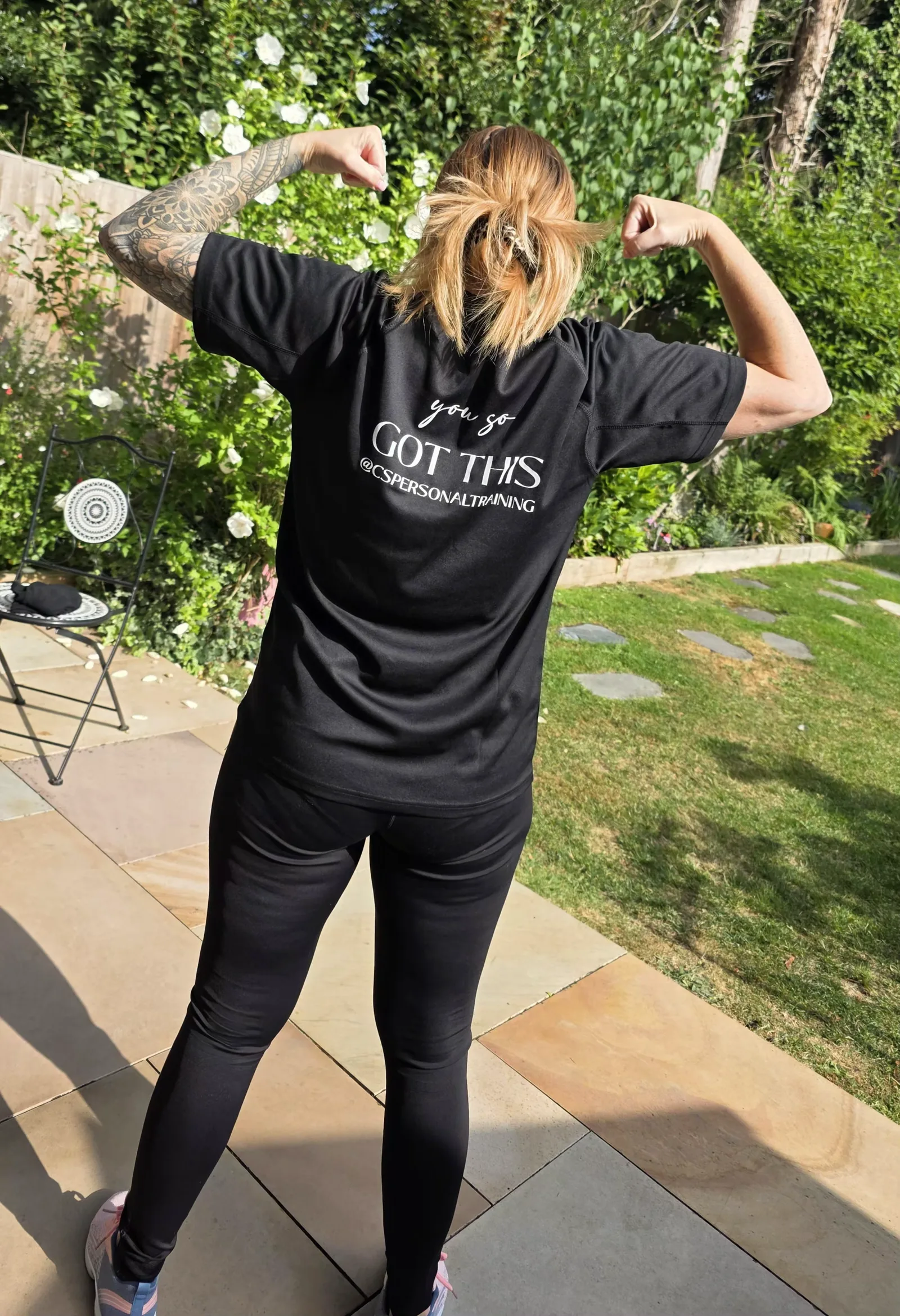 Carol from behind wearing the black tee, the back print reading you so got this.